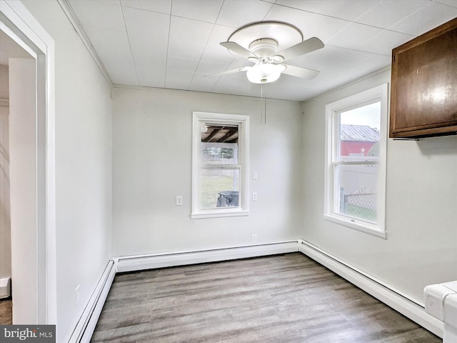 unfurnished dining area with ceiling fan, light hardwood / wood-style floors, and a baseboard heating unit