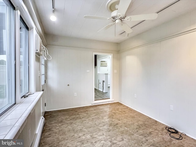 unfurnished room with ceiling fan, rail lighting, a wall unit AC, and a baseboard heating unit