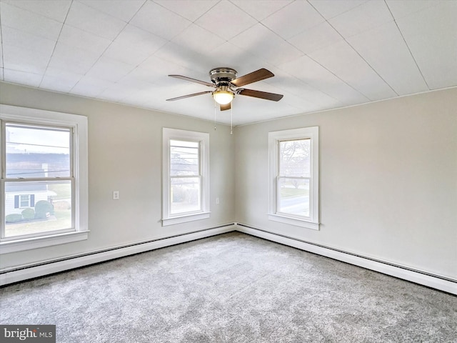 carpeted spare room featuring baseboard heating, plenty of natural light, and ceiling fan