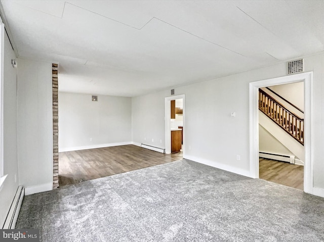 unfurnished living room with carpet and a baseboard heating unit