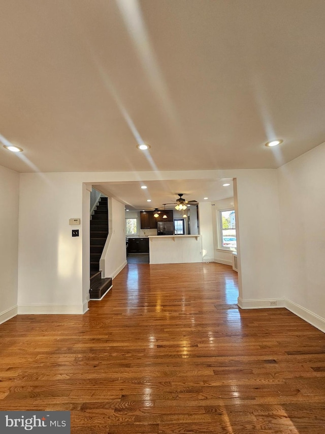 unfurnished living room with ceiling fan and dark hardwood / wood-style flooring