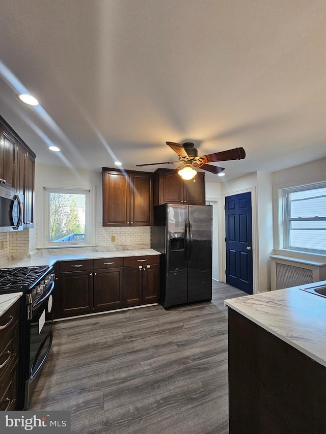 kitchen with decorative backsplash, appliances with stainless steel finishes, dark brown cabinets, ceiling fan, and dark wood-type flooring