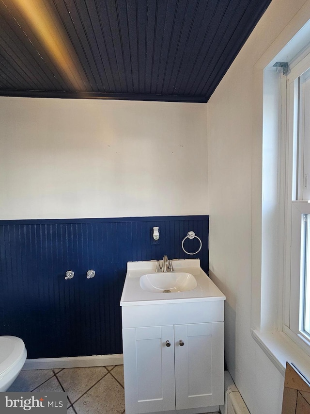 bathroom with vanity, wood walls, tile patterned floors, toilet, and wood ceiling