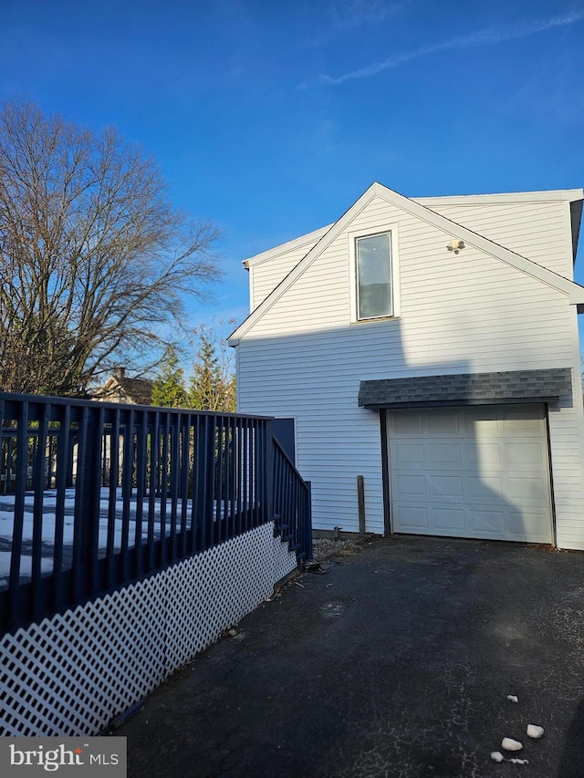 view of side of home with a garage and a deck