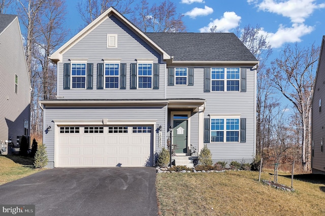 view of front of home with a garage and a front lawn