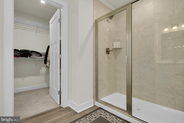 bathroom featuring wood-type flooring and a shower with shower door