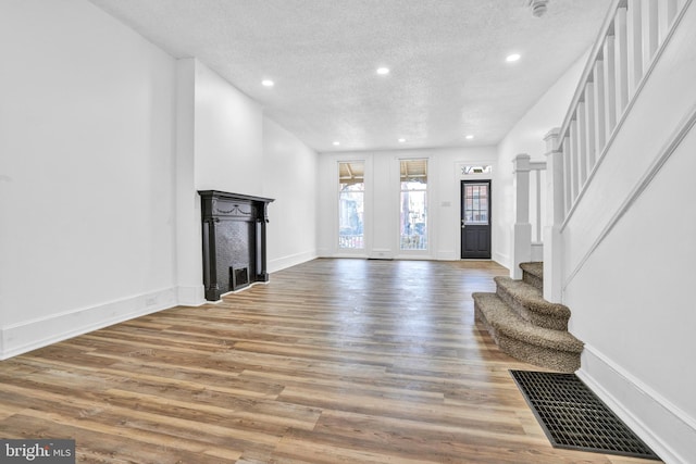 living room featuring wood-type flooring and a textured ceiling