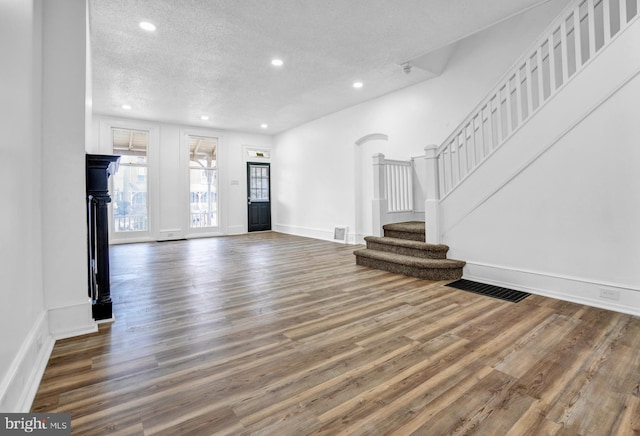 unfurnished living room featuring dark hardwood / wood-style floors and a textured ceiling