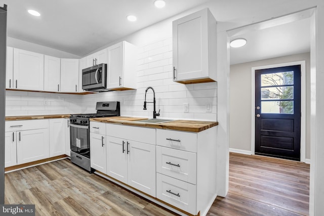 kitchen featuring white cabinets, wood counters, and stainless steel appliances