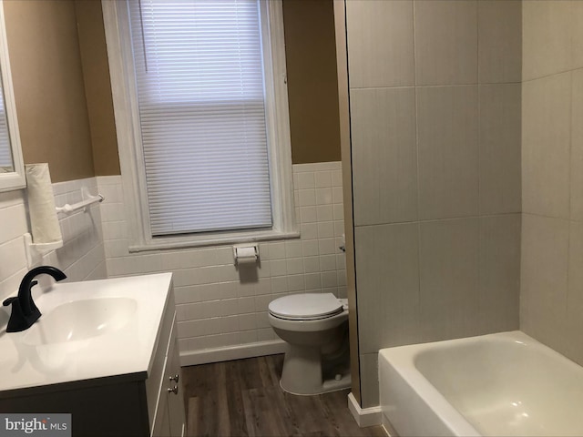 bathroom with hardwood / wood-style floors, vanity, toilet, and tile walls