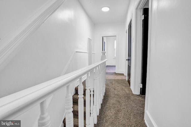 hallway with dark colored carpet