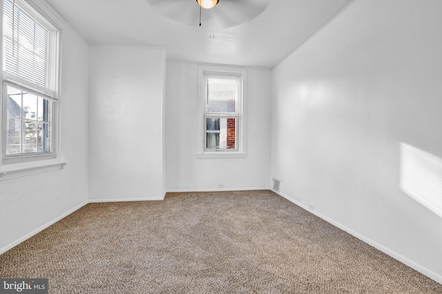 unfurnished room with ceiling fan, plenty of natural light, and carpet floors