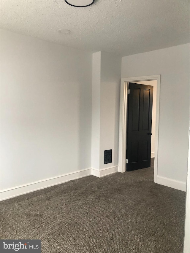 carpeted spare room with a textured ceiling