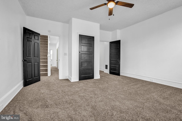 unfurnished bedroom with carpet flooring, ceiling fan, and a textured ceiling