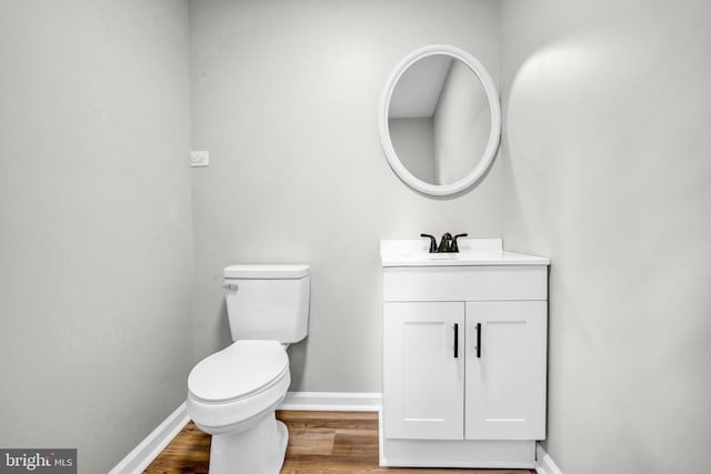 bathroom with hardwood / wood-style floors, vanity, and toilet