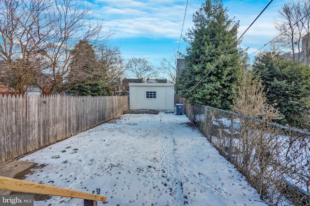 snowy yard featuring an outbuilding