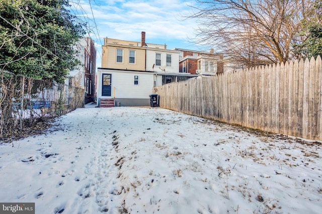 view of snow covered back of property