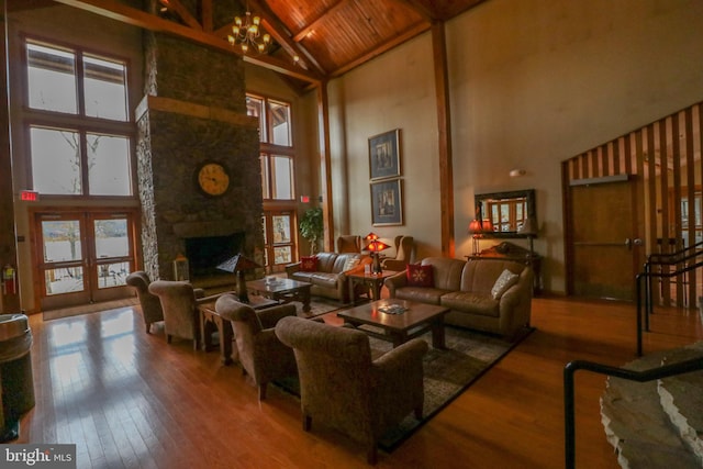 living room featuring hardwood / wood-style floors, wooden ceiling, high vaulted ceiling, a fireplace, and beamed ceiling