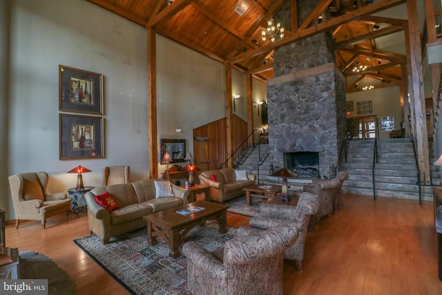 living room featuring wooden ceiling, a stone fireplace, beamed ceiling, high vaulted ceiling, and hardwood / wood-style floors