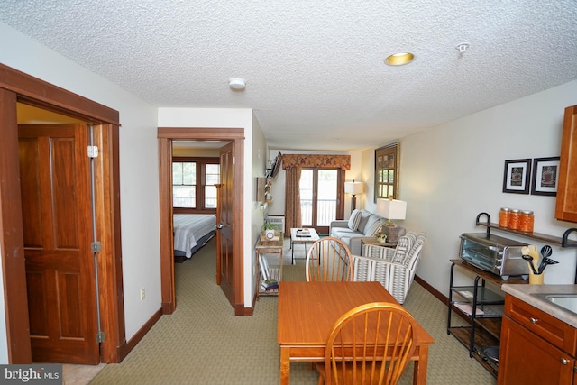 carpeted dining room with a textured ceiling