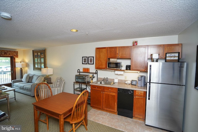 kitchen featuring appliances with stainless steel finishes, a textured ceiling, light tile patterned floors, and sink