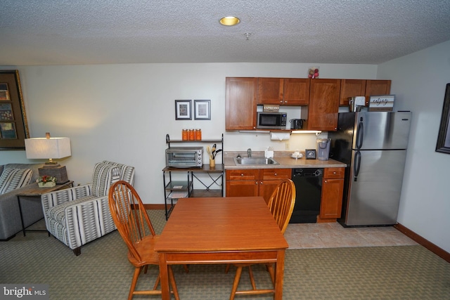 kitchen with light carpet, sink, a textured ceiling, and appliances with stainless steel finishes