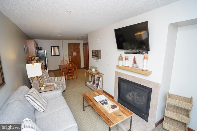 living room featuring a tile fireplace and a textured ceiling