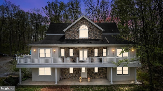 back house at dusk with a patio