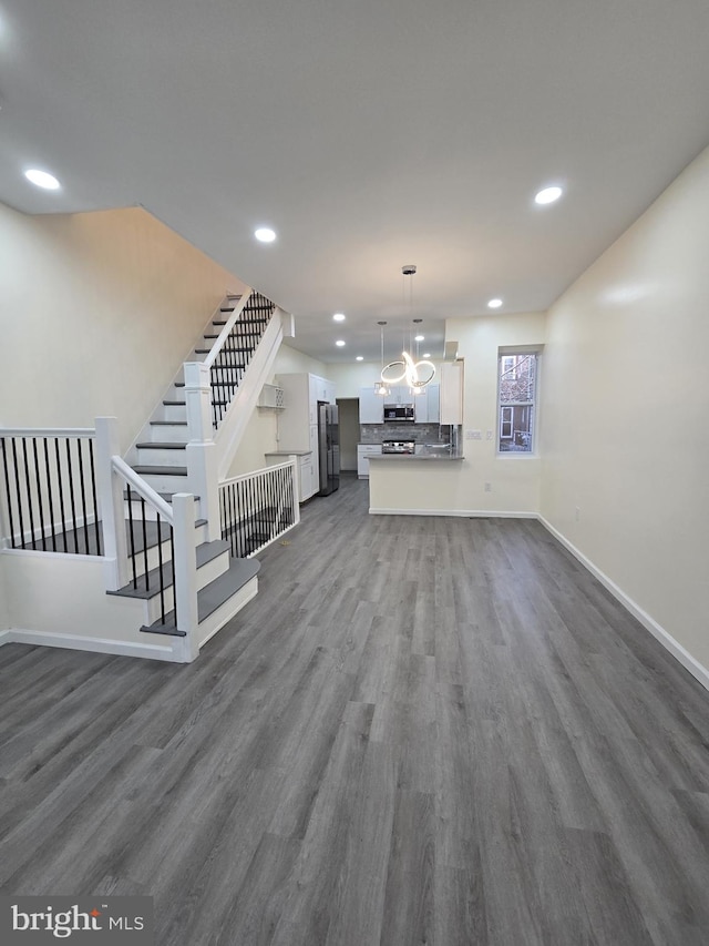 unfurnished living room with dark hardwood / wood-style flooring and an inviting chandelier