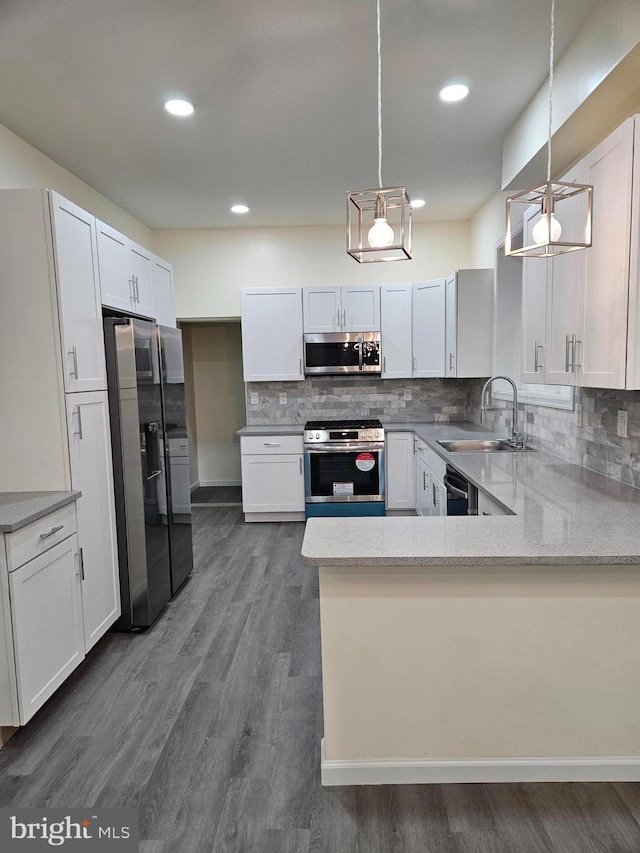 kitchen with white cabinetry, hanging light fixtures, stainless steel appliances, and sink