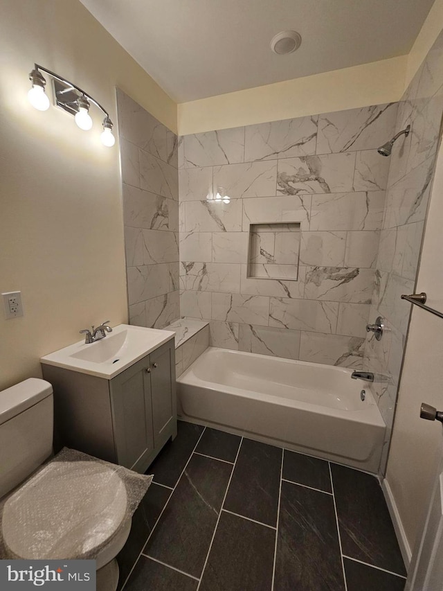 full bathroom featuring tile patterned flooring, vanity, tiled shower / bath combo, and toilet