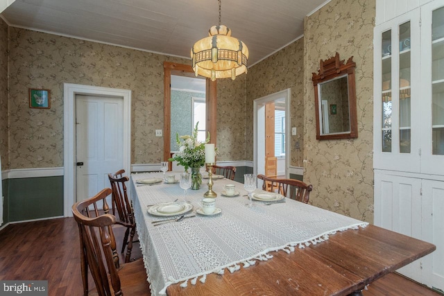 dining area with dark hardwood / wood-style flooring, ornamental molding, a baseboard radiator, and an inviting chandelier