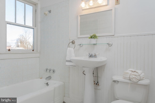 bathroom featuring a bath, toilet, and sink