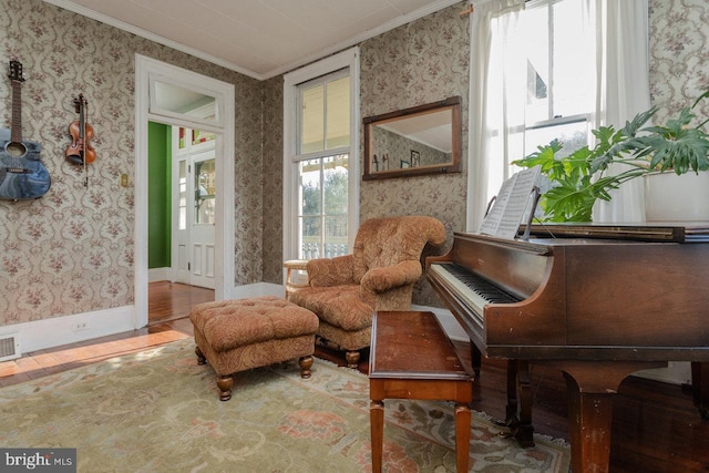 living area featuring crown molding and hardwood / wood-style flooring