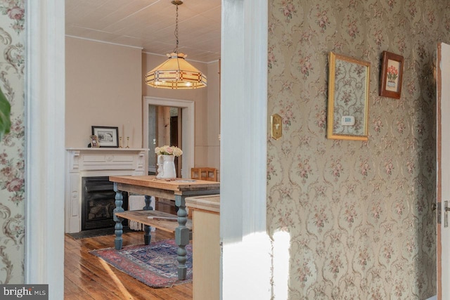 corridor with hardwood / wood-style floors and crown molding