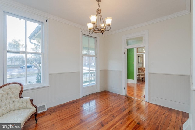 dining space featuring hardwood / wood-style floors, a chandelier, and ornamental molding