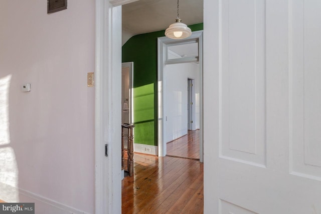 hallway featuring hardwood / wood-style floors and lofted ceiling