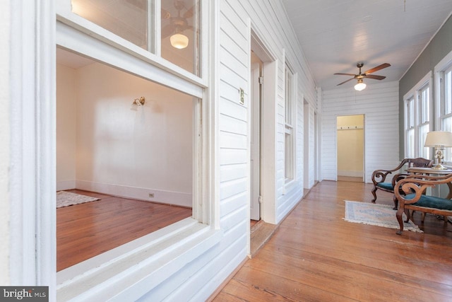 corridor with wood-type flooring and ornamental molding