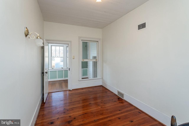 unfurnished room with dark hardwood / wood-style flooring