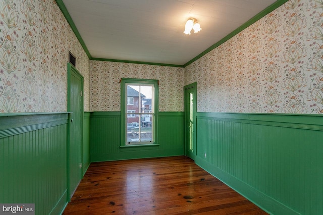 spare room with crown molding and dark hardwood / wood-style floors