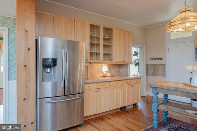 kitchen with stainless steel fridge with ice dispenser, light brown cabinets, light hardwood / wood-style floors, and pendant lighting