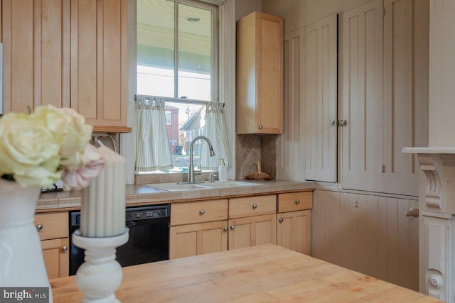 kitchen with backsplash, black dishwasher, sink, and light brown cabinetry