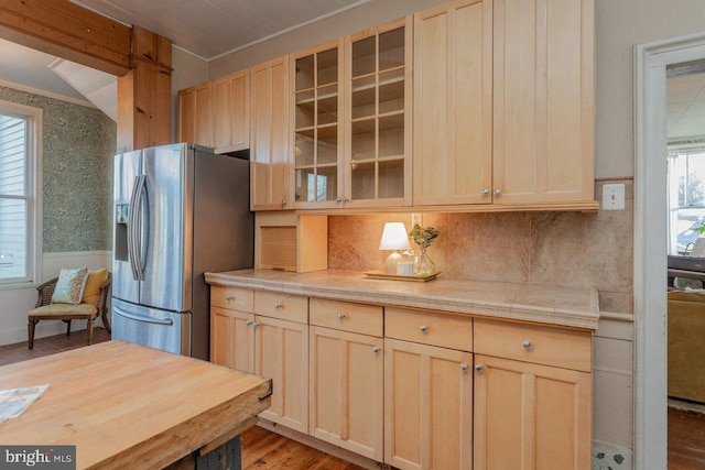 kitchen with hardwood / wood-style floors, ornamental molding, stainless steel refrigerator with ice dispenser, and light brown cabinetry