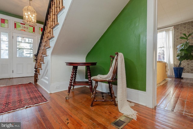 entrance foyer featuring wood-type flooring and a chandelier