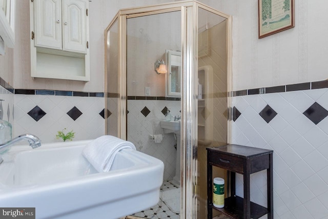 bathroom with an enclosed shower, tile patterned floors, and tile walls