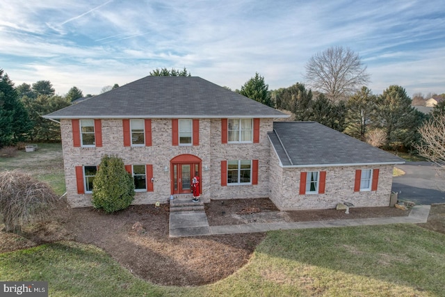 colonial inspired home featuring french doors and a front yard