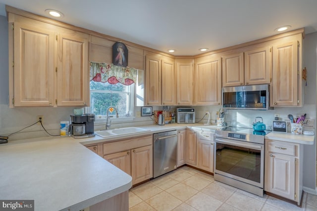 kitchen with sink, light tile patterned floors, light brown cabinets, and appliances with stainless steel finishes