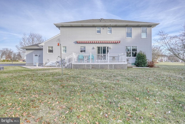 rear view of property featuring a yard and a deck