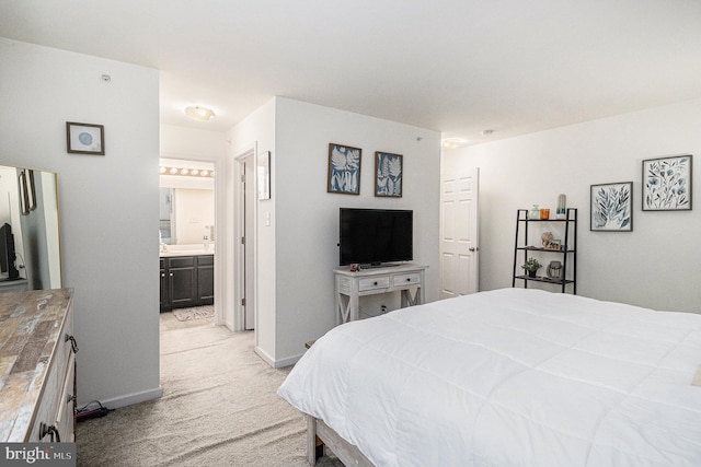 bedroom featuring ensuite bathroom and light colored carpet