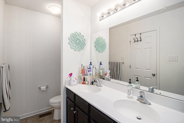 bathroom with tile patterned flooring, vanity, and toilet